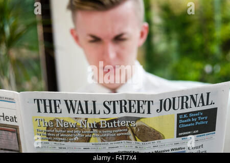 Un giovane uomo professionale la lettura del Wall Street Journal Foto Stock