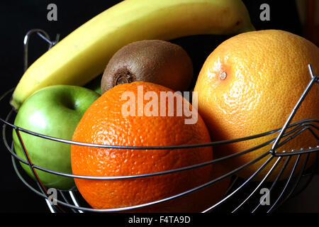 Vari frutti nel cestello di metallo su sfondo nero. Foto Stock
