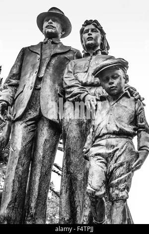 Statua di immigrati dispone di famiglia in bronzo sulla cima di una base di marmo in Centennial Park, Ybor City, FL Foto Stock