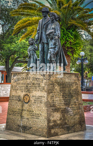 La statua dell'immigrato presenta una famiglia di quattro in bronzo in cima ad una base in marmo nel Centennial Park, dedicata al coraggio dell'immigrato, Ybor City, FL Foto Stock