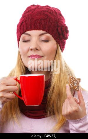 Sognando la donna nel cappello di lana e scialle decorato con pan di zenzero o biscotti di Natale e rosso tazza di tè caldo, il tempo di Natale, Foto Stock