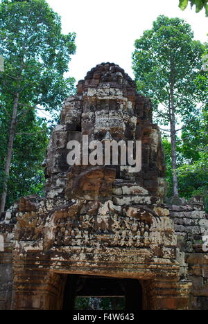 Gateway per antica Ta Som tempio di Angkor, Siem Reap, Cambogia. Gopura con un gigante di pietra di fronte e boschi in background. Foto Stock