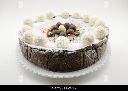 Torta di Pasqua con ripieno di ricotta e cioccolato decorate con uova di cioccolato e di zucchero a velo Foto Stock