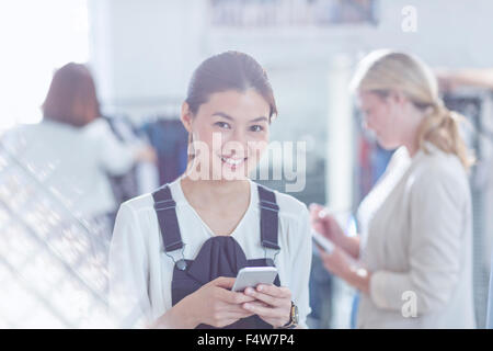 Ritratto fiducioso designer di moda scrivere messaggi con il telefono cellulare Foto Stock