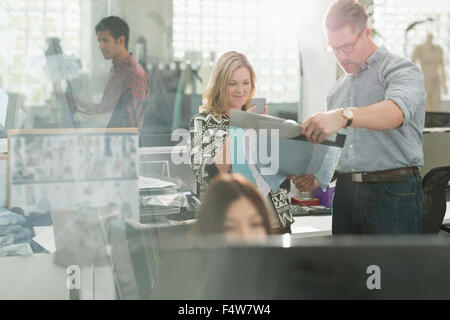 Designer di moda esaminando tessuto in ufficio Foto Stock