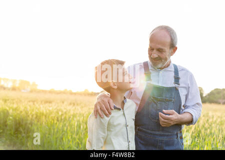 Nonno agricoltore e nipote abbracciando nella rurale campo di grano Foto Stock