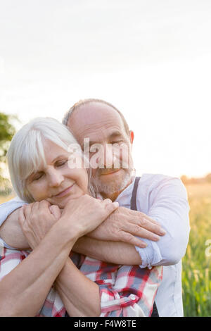 Close up ritratto sereno coppia senior abbraccia con gli occhi chiusi Foto Stock