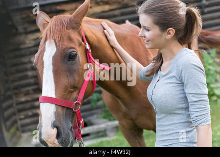 Donna petting cavallo Foto Stock