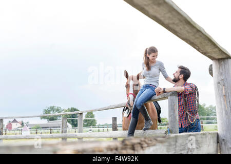 Giovane e cavallo al pascolo rurale recinzione Foto Stock