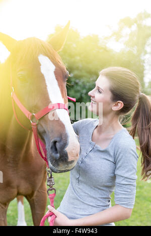 Donna sorridente con cavallo Foto Stock