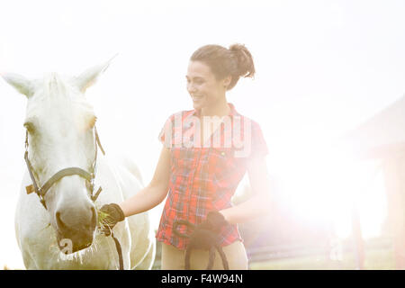 Donna sorridente con cavallo Foto Stock