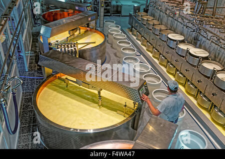 GRUYERE, Svizzera - 31 dicembre 2014: lavoratore del formaggio fabbrica di Gruyeres controllando la temperatura in vasche con latte Foto Stock