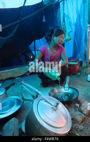 Kathmandu, Nepal. Xvii oct, 2015. Aiti Tamang dal Nepal si versa acqua in una padella in un campo di rifugiati in Thali sul bordo di Kathmandu, Nepal, 17 ottobre 2015. Come il resto delle 270 persone che rimanere nel campo Tamang è da Tatopani in Sindhupalchok che è il quartiere con il più alto numero di morti provocati dal terremoto del 25 aprile 2015. A volte i vicini e organizzazioni di soccorso di portare acqua e cibo e coperte per il camp, ma spesso non e con la gente del camp sono lasciati a loro stessi. Foto: Doreen Fiedler/dpa/Alamy Live News Foto Stock