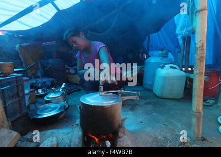 Kathmandu, Nepal. Xvii oct, 2015. Aiti Tamang dal Nepal cuochi con una pentola a pressione in un campo di rifugiati in Thali sul bordo di Kathmandu, Nepal, 17 ottobre 2015. Come il resto delle 270 persone che rimanere nel campo Tamang è da Tatopani in Sindhupalchok che è il quartiere con il più alto numero di morti provocati dal terremoto del 25 aprile 2015. A volte i vicini e organizzazioni di soccorso di portare acqua e cibo e coperte per il camp, ma spesso non e con la gente del camp sono lasciati a loro stessi. Foto: Doreen Fiedler/dpa/Alamy Live News Foto Stock