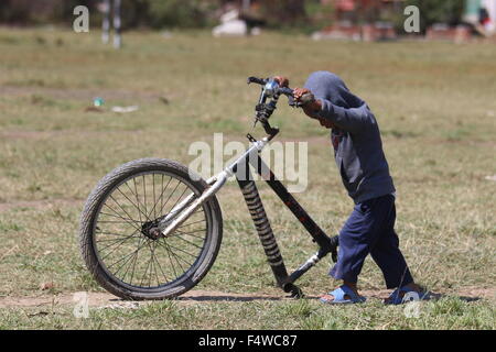 Kathmandu, Nepal. Xvii oct, 2015. Un bambino gioca con la rottura di una bicicletta al campo profughi in Thali sul bordo di Kathmandu, Nepal, 17 ottobre 2015. Come il resto delle 270 persone che rimanere nel campo egli è da Tatopani in Sindhupalchok che è il quartiere con il più alto numero di morti provocati dal terremoto del 25 aprile 2015. A volte i vicini e organizzazioni di soccorso di portare acqua e cibo e coperte per il campo profughi, ma spesso non e con la gente del camp sono lasciati a loro stessi. Foto: Doreen Fiedler/dpa/Alamy Live News Foto Stock