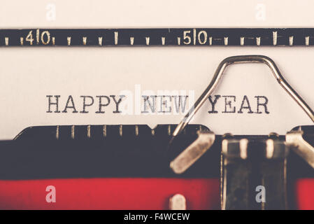 Felice anno nuovo su una vecchia macchina da scrivere macchina, hipster stile di vita lettera di vacanza e biglietto di auguri, retro tonica, il fuoco selettivo Foto Stock