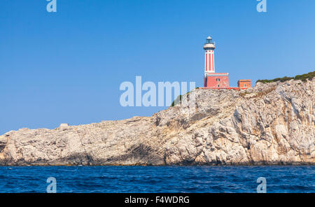 Punta Carena. Faro rosso torre sorge sulla costa rocciosa di Isola di Capri, Italia Foto Stock