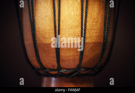 Dettagli di un vecchio di legno djembe, closeup vista sulle funi, della pelle e del legno. Foto Stock