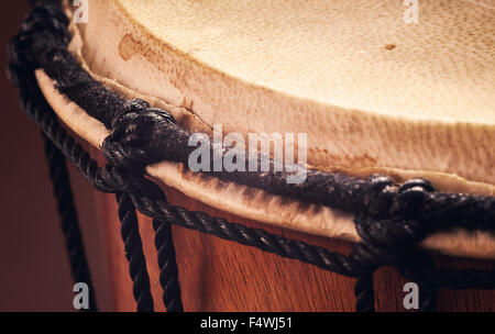 Dettagli di un vecchio di legno djembe, closeup vista sulle funi, della pelle e del legno. Foto Stock