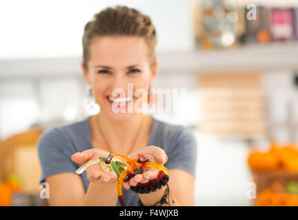 Primo piano sulla colorata halloween worm gommoso caramelle nelle mani della donna. I ragazzi potranno essere stordito! Tradizionale autunno vacanza. Foto Stock