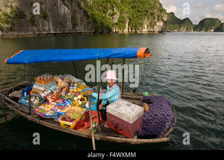 Barca donna venditore in Halong Bay, Vietnam. Snack Drink hat venditore barca a remi Halong Bay Vietnam. Foto Stock