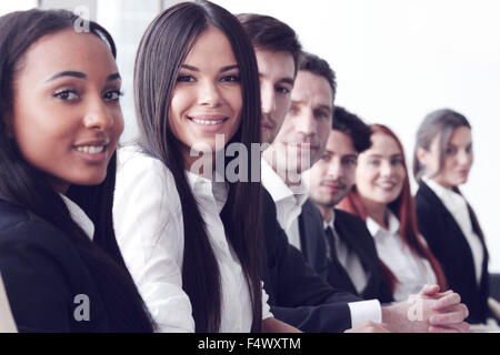 La gente di affari seduti in una fila e lavorare, concentrarsi sulla bella donna Foto Stock
