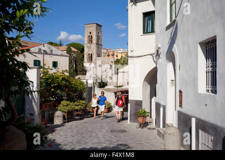 Strada stretta, Ravello, Costiera Amalfitana, con Duomo torre campanaria in background e il turista giovane Foto Stock