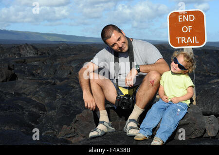 Il padre con la sua doughter alla fine del sentiero. Lava nera montagne vicino alla costa e catena di autostrada del cratere Road. Hawai'i Volc Foto Stock