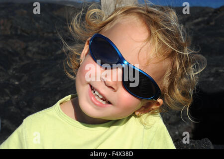 Ragazza con occhiali da sole alla fine del sentiero. Lava nera montagne vicino alla costa e catena di autostrada del cratere Road. Hawai'i Volcanoe Foto Stock