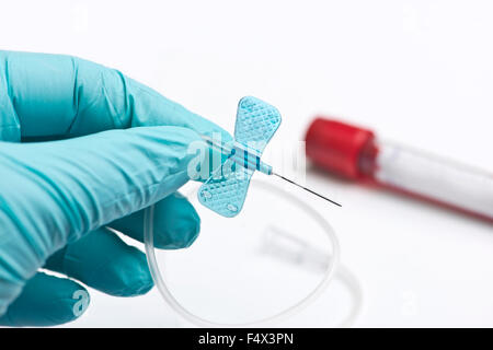 Provetta per la raccolta di sangue e piccoli blue butterfly catetere detenute da infermiere. Foto Stock