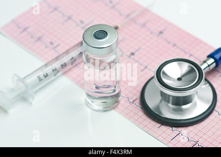 Elettrocardiografo con siringa, fiala, e stetoscopio. Foto Stock