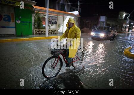 Ameca, Messico. 23 Ott, 2015. Un uomo che cavalca la sua bicicletta sotto la pioggia causata dall'huricane 'Patricia' in Ameca, stato di Jalisco, Messico, su Ott. 23, 2015. Un ora dopo l uragano Patricia fatto approdo venerdì sera nello stato messicano di Jalisco, portando i forti venti e piogge oltre la parte occidentale del paese, è stato retrocesso di un uragano di categoria 4. Credito: Pedro Mera/Xinhua/Alamy Live News Foto Stock