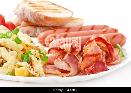 Prima colazione inglese - uova strapazzate, bacon, salsicce e pane tostato Foto Stock