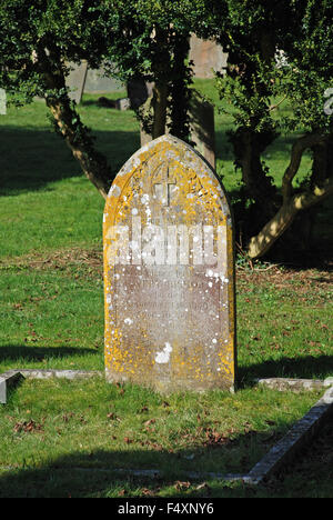 Vecchia lastra tombale nel cimitero coperte di muschio giallo all'esterno della chiesa di San Giovanni Battista a Burford, Inghilterra Foto Stock