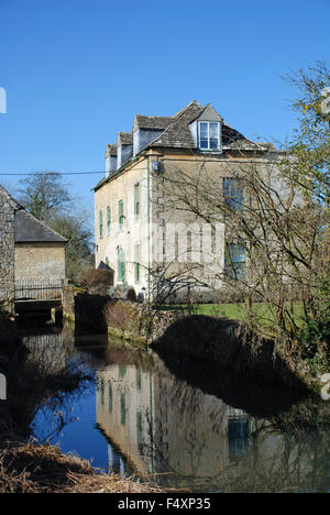 Vecchia casa e acqua simmetria di riflessione a Burford, Oxfordshire, Inghilterra Foto Stock