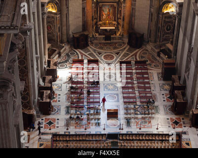 Vista panoramica su i credenti nel coro di un tranquillo corridoio laterale all'interno della Basilica di San Pietro in Vaticano. Foto Stock