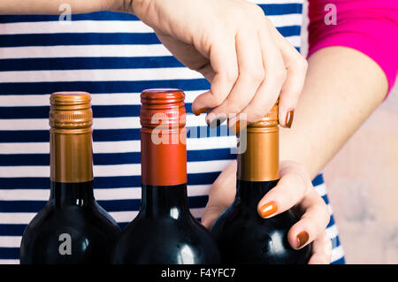 Cameriera di donna apre una bottiglia di vino rosso Foto Stock