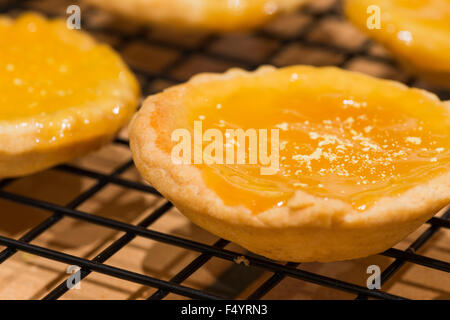 Cagliata di limone Marmellata crostata di torta crostate pronti per la consumazione di pasti caldi fatti in casa al di fuori del forno dessert in una riga Foto Stock