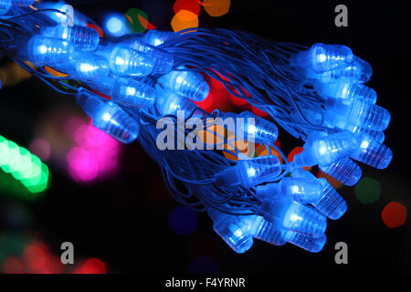 Un mazzetto di linea di luci blu utilizzato per la decorazione in Diwali e feste di Natale, sullo sfondo di altri paglierino colorati Foto Stock