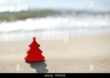 Red Decorazione per albero di Natale sulla spiaggia di sabbia Foto Stock