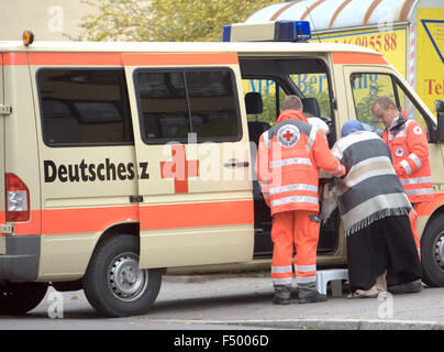 I membri della Croce Rossa tedesca aiuta una donna evacuare la sua casa durante l'eliminazione della bomba procedure, a Berlino, Germania, 25 ottobre 2015. Un Americano 250kg bomba dalla seconda guerra mondiale è stato trovato su un sito di costruzione vicino al Museo Ebraico e deve essere ridimensionato. Foto: Paolo ZINKEN/DPA Foto Stock