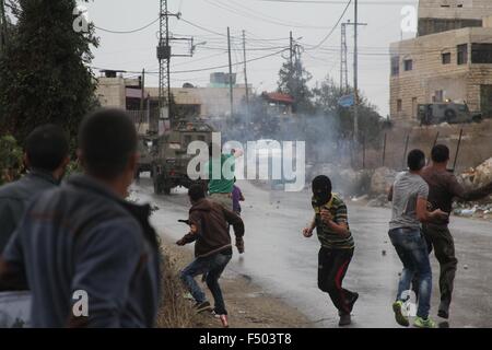 (151025) -- Hebron, 25 ottobre 2015 (Xinhua) -- dimostranti palestinesi lanciare sassi verso i soldati israeliani durante scontri nella West Bank village di Si'EER, a nord di Hebron, il 25 ottobre 2015. Fin dai primi di ottobre, 58 palestinesi sono stati uccisi e più di 2.000 feriti nell'ondata di violenti scontri tra Israele e i palestinesi in Cisgiordania e nella Striscia di Gaza e di Gerusalemme est, secondo la sanità palestinese ministero.(Xinhua/Mamoun Wazwaz) Foto Stock