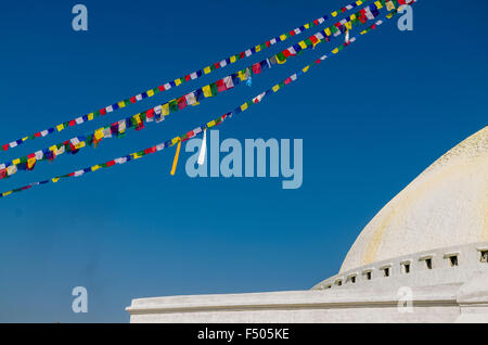 Dettaglio di boudnath stupa con la preghiera le bandiere e cielo blu Foto Stock