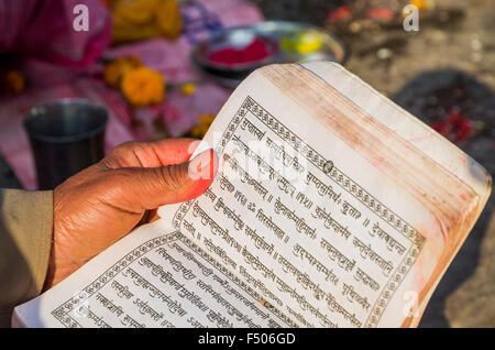 Devota lettura nelle sacre scritture, scritto in caratteri hindi Foto Stock