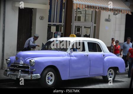 Il traffico cop parlando al tassista di un vintage mauve cabina su un angolo di strada in Havana Cuba Foto Stock