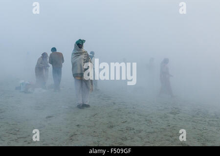 Le persone che la vasca da bagno nella nebbia di mattina presto a sangam, alla confluenza dei fiumi Gange e yamuna e saraswati, a kumbha Foto Stock