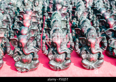 Molte merci differenti come abilmente progettato piccole ganesha statue sono presentati per la vendita al fleamarket settimanale Foto Stock