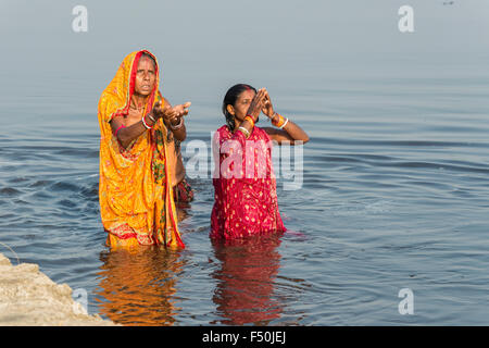 Due pellegrini femminile, le donne sono tenendo bagno e pregando nel sacro fiume Yamuna Foto Stock