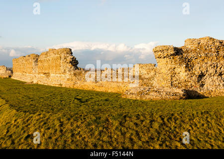 Richborough castello romano nel Kent, Inghilterra. Saxon Shore Fort. Iii secolo la parete esterna della fortezza con fossato difensivo. Ora d'oro. Foto Stock