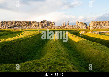 Inghilterra, Kent, Richborough castello romano. Inizio del I secolo i fossati con le rovine di più tardi del III secolo parete principale dalla riva sassone fort. Foto Stock